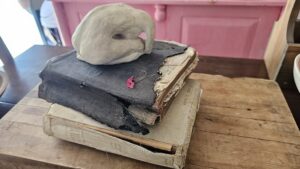 Sculpture of a torso bowed in prayer, photographed atop a Bible.